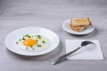 fried eggs with croutons and onions