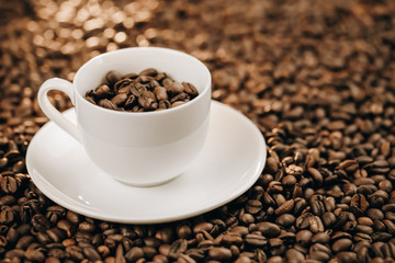 Roasted coffee beans with cup on background