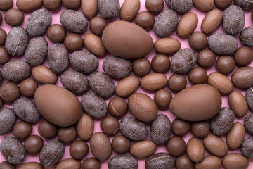 collection of chocolate Easter eggs over pink, holiday background
