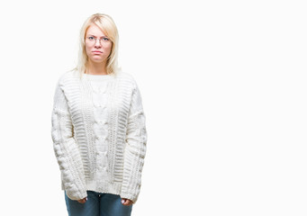 Young beautiful blonde woman wearing winter sweater and glasses over isolated background skeptic...