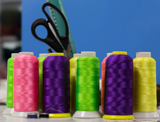 the thread of acidic flowers in the bobbins stand on a blue background