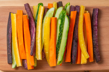 top view of colorful carrots and cucumbers vegetables julienned for snack on wooden board, concept...