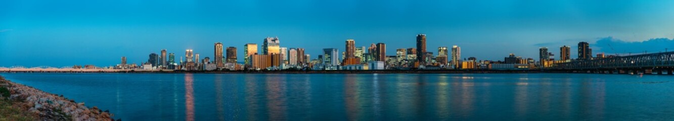 beautiful landscape of Osaka city with modern buildings and river, Japan, sunset, panorama