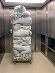 Collected laundry bags in the hospital are transported in a transport box. Concept: Health and...