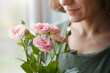 cute young woman smelling pink roses