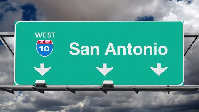 San Antonio Texas interstate route 10 overhead freeway directional arrow sign with time lapse clouds.