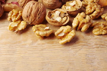 Inshell walnuts and walnut kernels on a wooden table