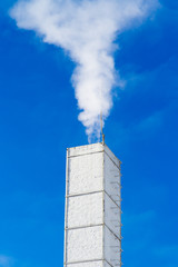 White chimney with smoke.