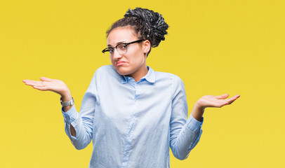 Young braided hair african american business girl wearing glasses over isolated background clueless...