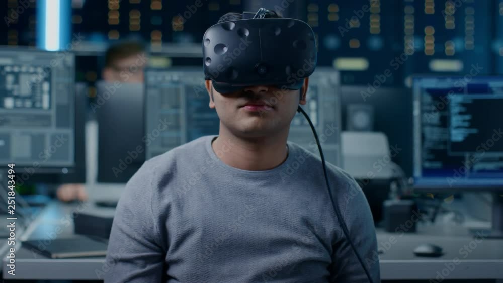 Aufkleber Software Delevoper Wearing Virtual Reality Headset Gesturing with His Head, Developing and Programming VR Game or Application. In the Background Technology Developing Studio with Computers Monitors