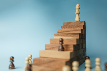 Chess standing on a pyramid of wooden building blocks