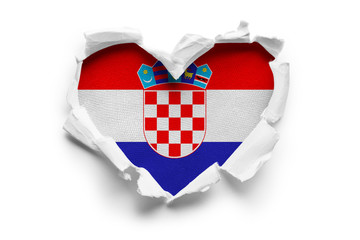 Heart shaped hole torn through paper, showing satin texture of flag of Croatia. Isolated on white...