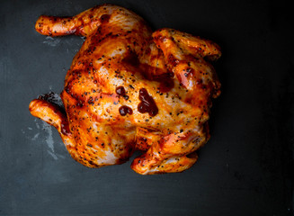 raw whole chicken with red souce with spices