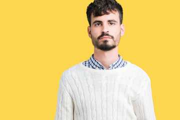 Young handsome man wearing winter sweater over isolated background Relaxed with serious expression on face. Simple and natural looking at the camera.
