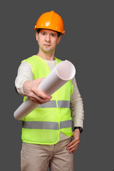 the civil engineer in a helmet gives documents, stretches drawings forward