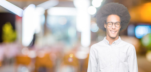 Young african american man with afro hair wearing glasses winking looking at the camera with sexy...