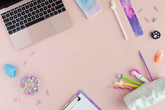 Flat lay of kawaii stylish school stationery and laptop on pink background. Back to school concept. Top view of pastel office desk