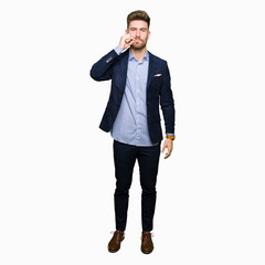 Fototapeta premium Young handsome bussines man mouth and lips shut as zip with fingers. Secret and silent, taboo talking