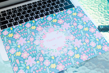 A thank you card sitting on a computer keyboard, online thank you.