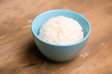 White Rice in Blue Bowl on Wooden Background