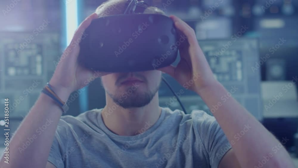 Aufkleber Software Delevoper Wearing Virtual Reality Headset Gesturing with His Head, Developing and Programming VR Game or Application. In Background Technology Developing Studio with Computers and Monitors