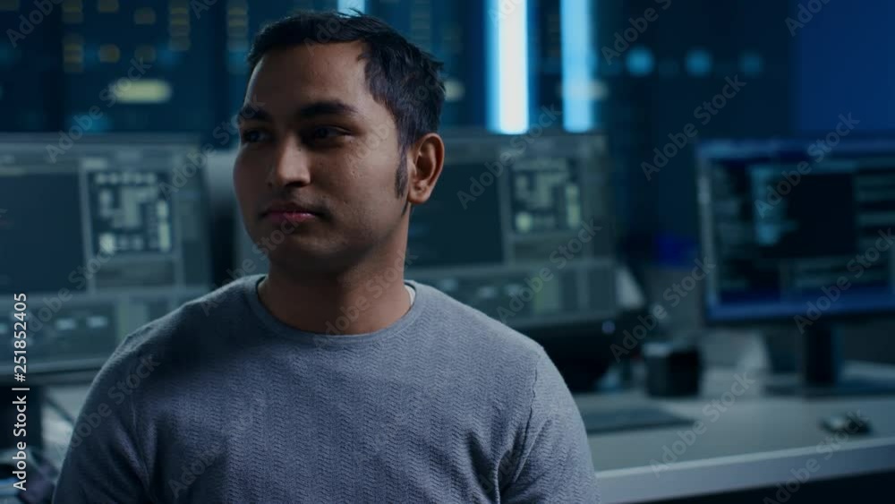 Aufkleber Portrait of Handsome Indian Software Developer Posing Calmly. In the Background Technologically Advanced Data Center with Multiple Computer Displays. Fade Out Special Effect