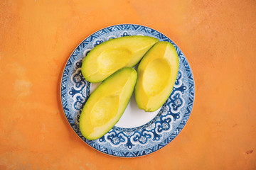 Avocados on Blue Plate and Orange Background