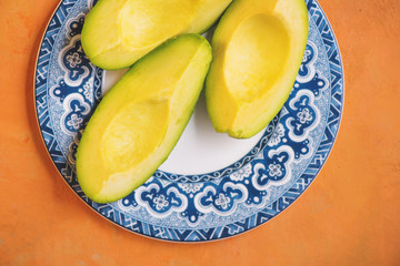 Avocados on Blue Plate and Orange Background