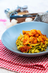 Cooked pasta with peeled shrimp, coconut milk sauce and broccoli