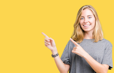 Beautiful young woman wearing oversize casual t-shirt over isolated background smiling and looking at the camera pointing with two hands and fingers to the side.