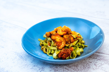 Cooked pasta with peeled shrimp, coconut milk sauce and broccoli