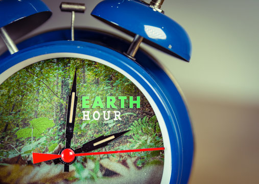 Retro alarm clock with nature background symbolizing Earth hour towards the end of March or earth day on April 22