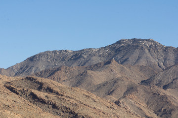 Fototapeta na wymiar Rocky desert at day with harsh sunlight and blue sky 