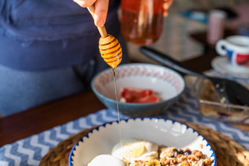 dripping honey on baked oatmeal with banana, blueberries, walnut and raisins.