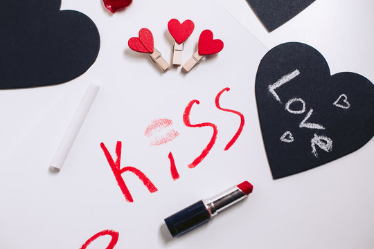 Love inscription, red lipstick. Black valentines and decorative clothespins
