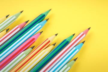 multicolored pencils on a yellow isolated background