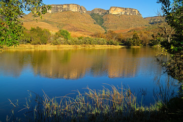 Sandstone mountains and pond with reflection in water, Royal Natal National Park, South Africa.