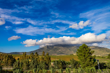 Sicilian landscape of green hill with cloud sky, countryside