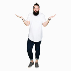 Young hipster man with long hair and beard wearing casual white t-shirt clueless and confused...