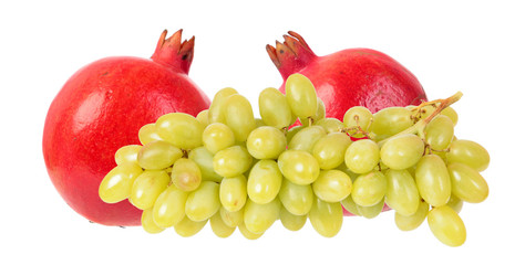 Two ripe red pomegranate fruits and green grapes isolated on white background