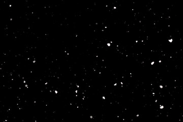 Snowstorm texture. Bokeh lights on black background, shot of flying snowflakes in the air