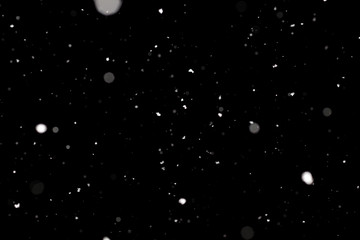 Snowstorm texture. Bokeh lights on black background, shot of flying snowflakes in the air