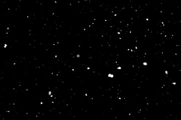 Snowstorm texture. Bokeh lights on black background, shot of flying snowflakes in the air