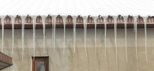 Icicles on vintage roof closeup. Winter weather concept. Froze and ice background. Christmas weather concept. Snow and icicle. Melting icicles. Long sharp icicles. Frozen water. Cold weather concept
