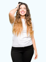 Young beautiful woman wearing casual white t-shirt Smiling confident touching hair with hand up gesture, posing attractive