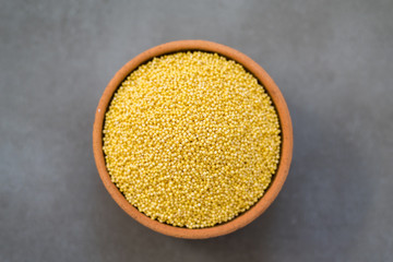 Organic millet seeds in a ceramic bowl, healthy and is gluten-free food.