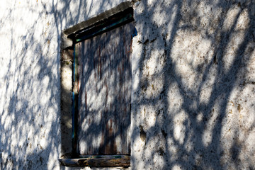 Dilapidated rotten boarded up window on derelict building awaiting demolition
