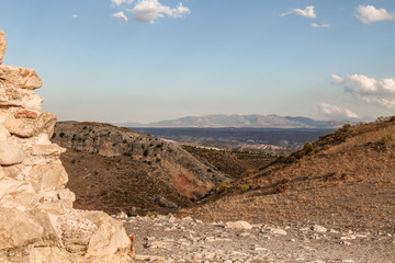 beautiful view of rocky hilly mountain landscape scenery and stone wall on the side with sunny blue sky