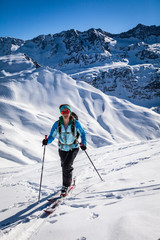 Fototapeta na wymiar A young woman is going for some ski touring in the backcountry.