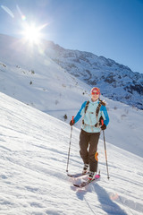 Fototapeta na wymiar A young woman is going for some ski touring in the backcountry.